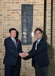 写真:消費者庁新未来創造戦略本部の看板の前で握手をする伊東大臣と後藤田徳島県知事