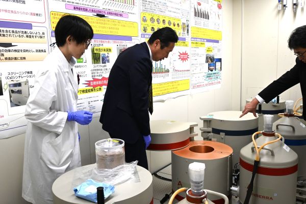 写真:装置を目の前に説明を受けている様子