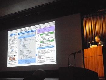 (写真)高田消費者庁政策立案総括審議官による<br>成果報告