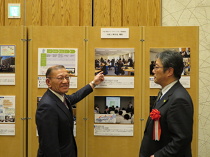 (写真)宮腰大臣にオフィスの取組を説明する<br>金子参事官