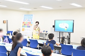 写真:参加者である子どもたちに、講師がモニターで動画を見せながら説明している様子