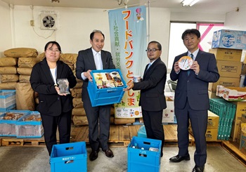 職員から川上事務局長へ食品が渡される様子