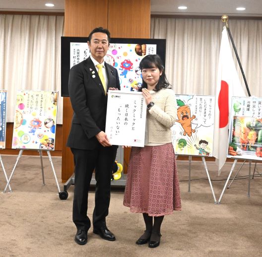 写真:伊東大臣と受賞者が、受賞作品の川柳の書かれたパネルを掲げ持っている