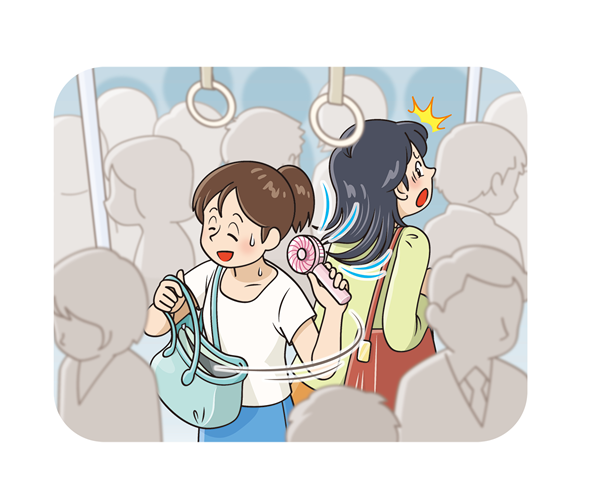 電車内で携帯用扇風機を使用している